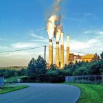 smoke and steam rise from a power plant