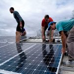 people installing solar panels