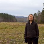 woman next to pipeline marker