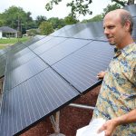 A man stands with solar panels