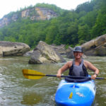 Kayaker in boat on water posing for picture