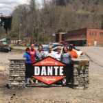 Community members stand with a new welcome sign