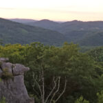 green mountains stretch into the horizon at dusk