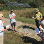 people speaking by solar panels