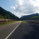 Empty train cars along a mountain road