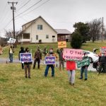 people hold signs supporting the tree-sitters