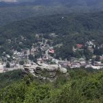 View of small town surrounded by mountains, American flag in foreground