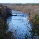 wide blue river flanked by autumn trees