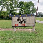 A sign advertises a No Pipelines meeting.